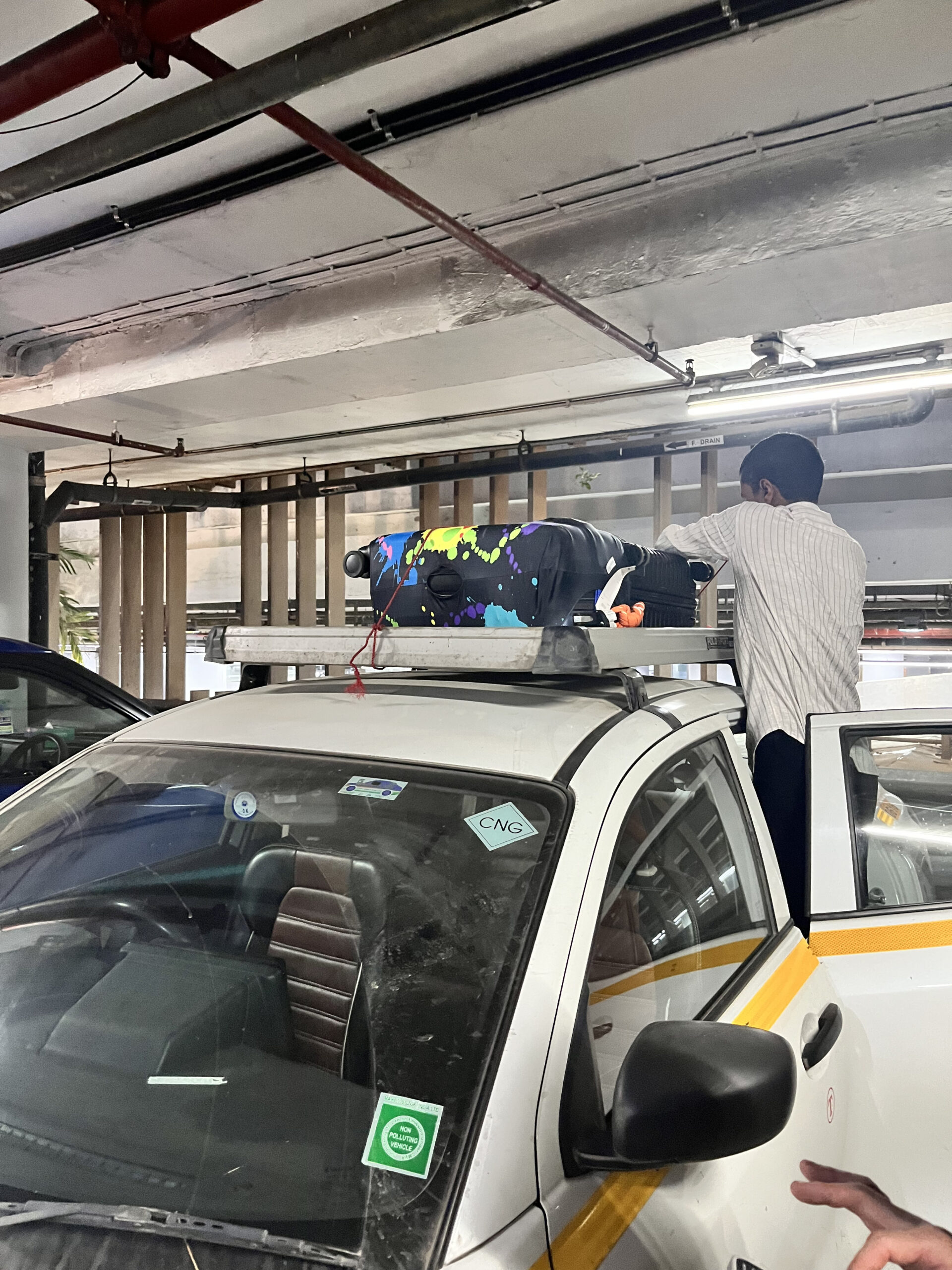 インド現地でUber SUVの屋根にスーツケースを積むドライバーの作業中の様子